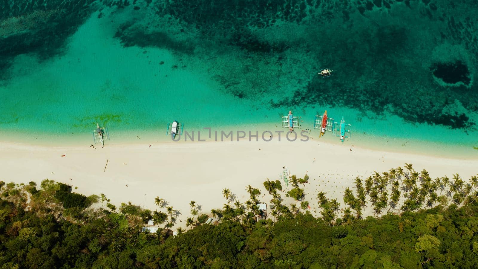 Sandy beach and turquoise water in the tropical resort of Boracay, Puka shell beach, Philippines aerial view. White beach with tourists. Summer and travel vacation concept.