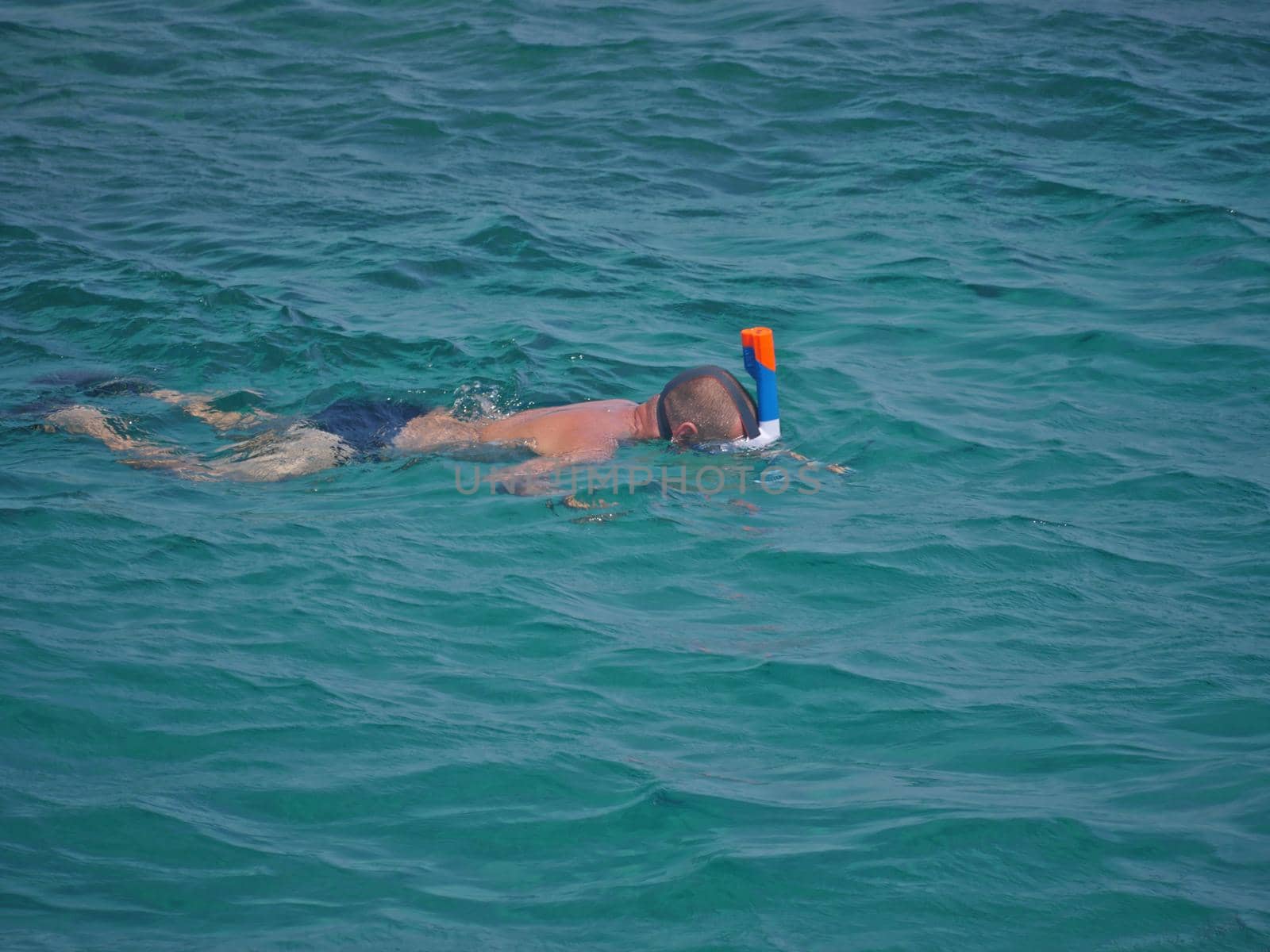 man in a mask dives under the water