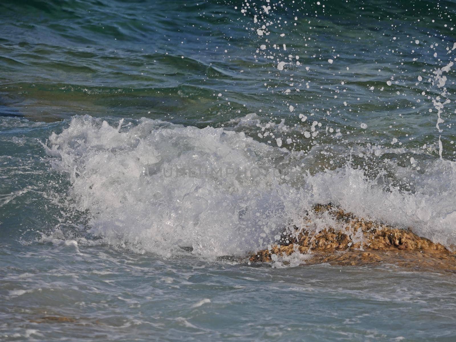 sea wave crashing against the rock cliff