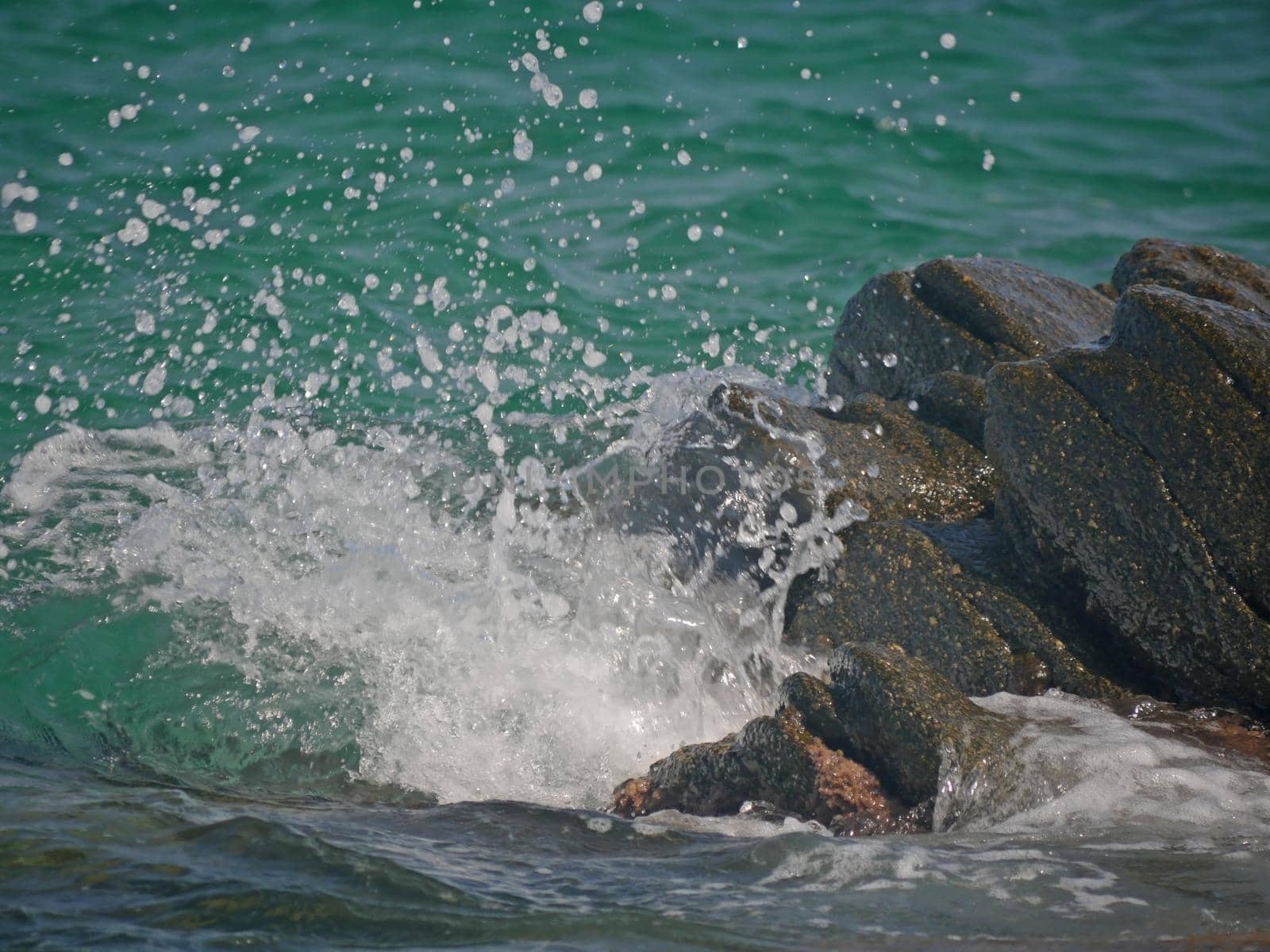 sea wave crashing against the rock cliff