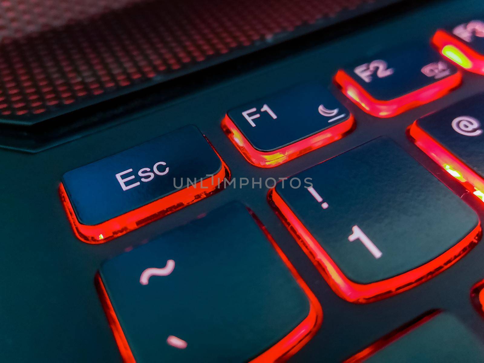 Keyboard of laptop highlighted by red lights