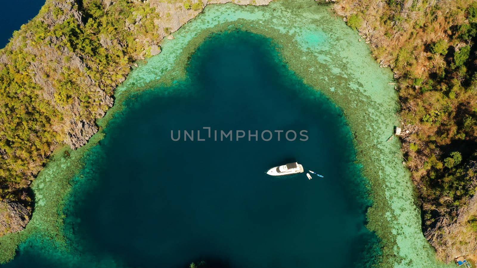 Aerial drone speed boat with tourists in beautiful lagoon. tropical landscape. blue lagoon surrounded by rocks on tropical island. Seascape, tropical landscape. Palawan, Philippines, Busuanga