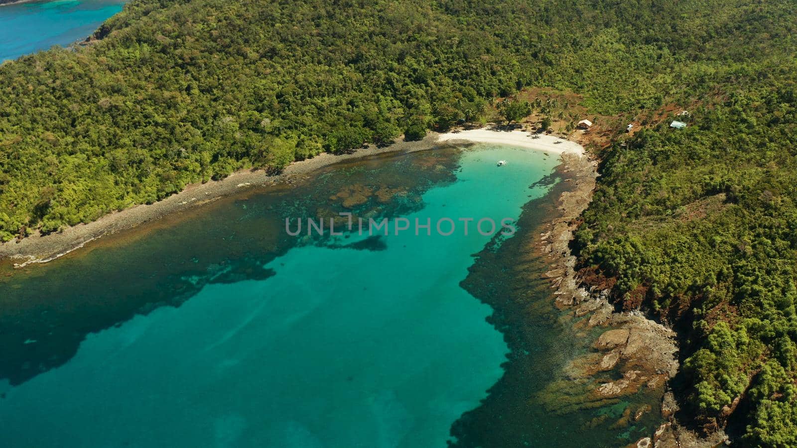 aerial view tropical sandy beach with coral reef and blue lagoon surrounded by rainforest. Palawan, Philippines. tropical landscape. Seascape island and clear blue water. Summer and travel vacation concept