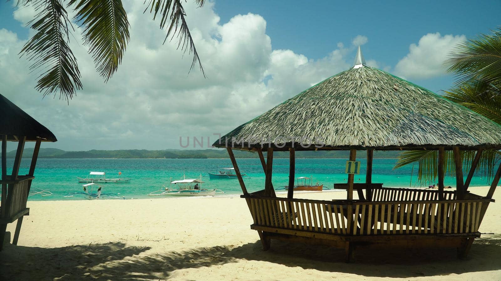 Bungalow on a tropical beach with palm trees and blue sea of Daco, Philippines. Summer and travel vacation concept