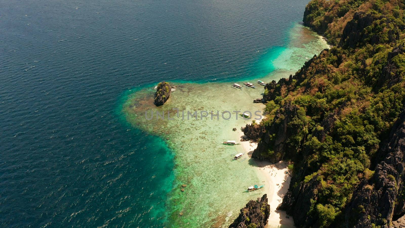 aerial view tropical lagoon with sandy beach surrounded by cliffs. El nido, Philippines, Palawan. beautiful lagoon and karst scenery.