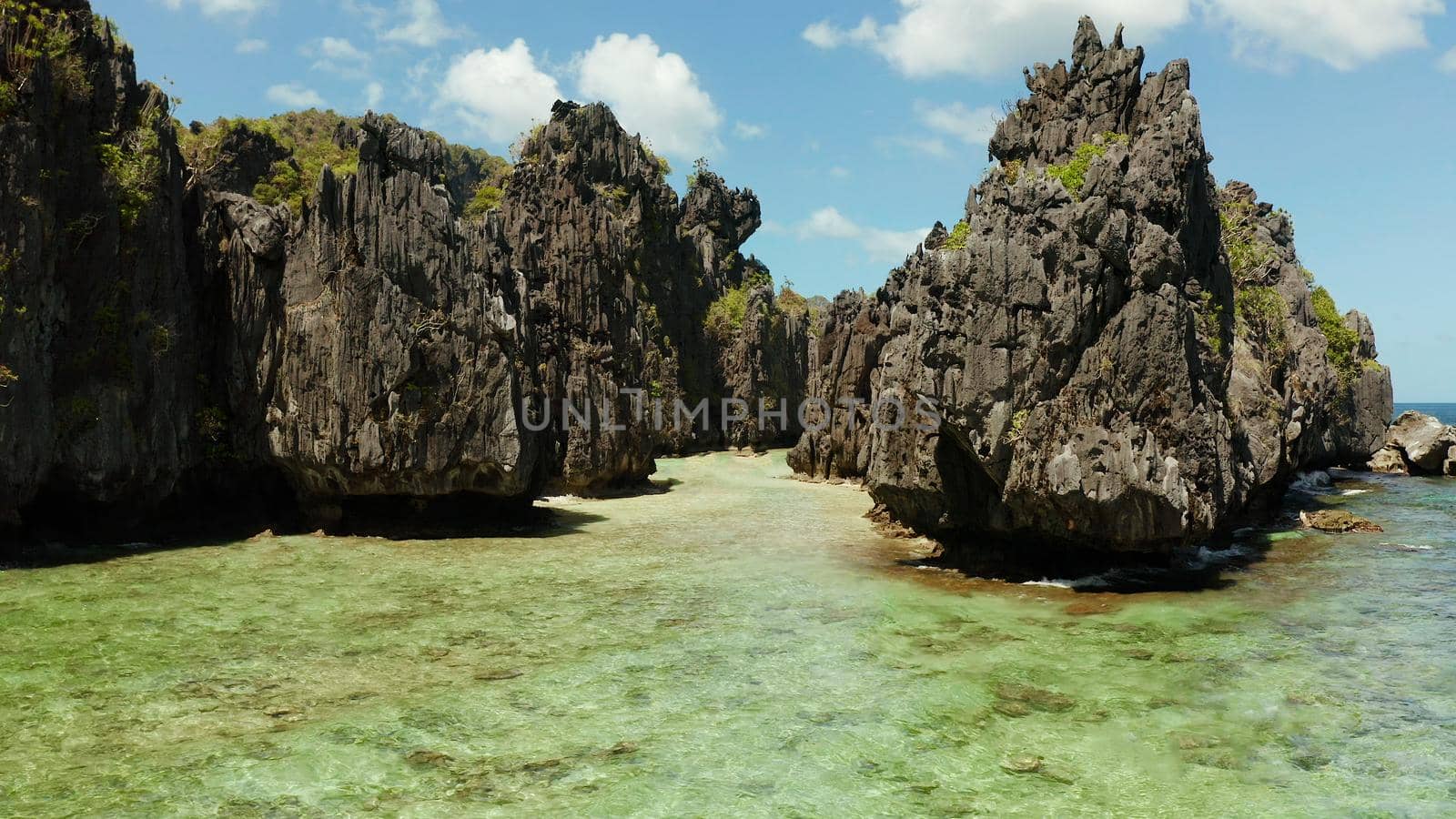 aerial view of tropical lagoon with sandy beach surrounded by cliffs. El nido, Philippines, Palawan. beautiful lagoon and karst scenery.