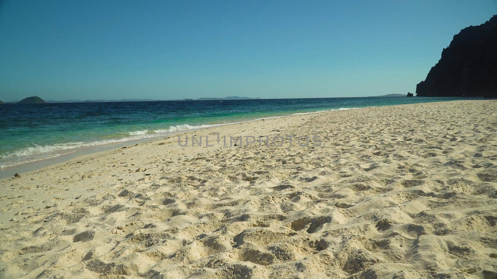 Tropical sandy beach and blue sea with waves. Malajon Island, Philippines, Palawan. Summer and travel vacation concept. beach and blue clear sea water