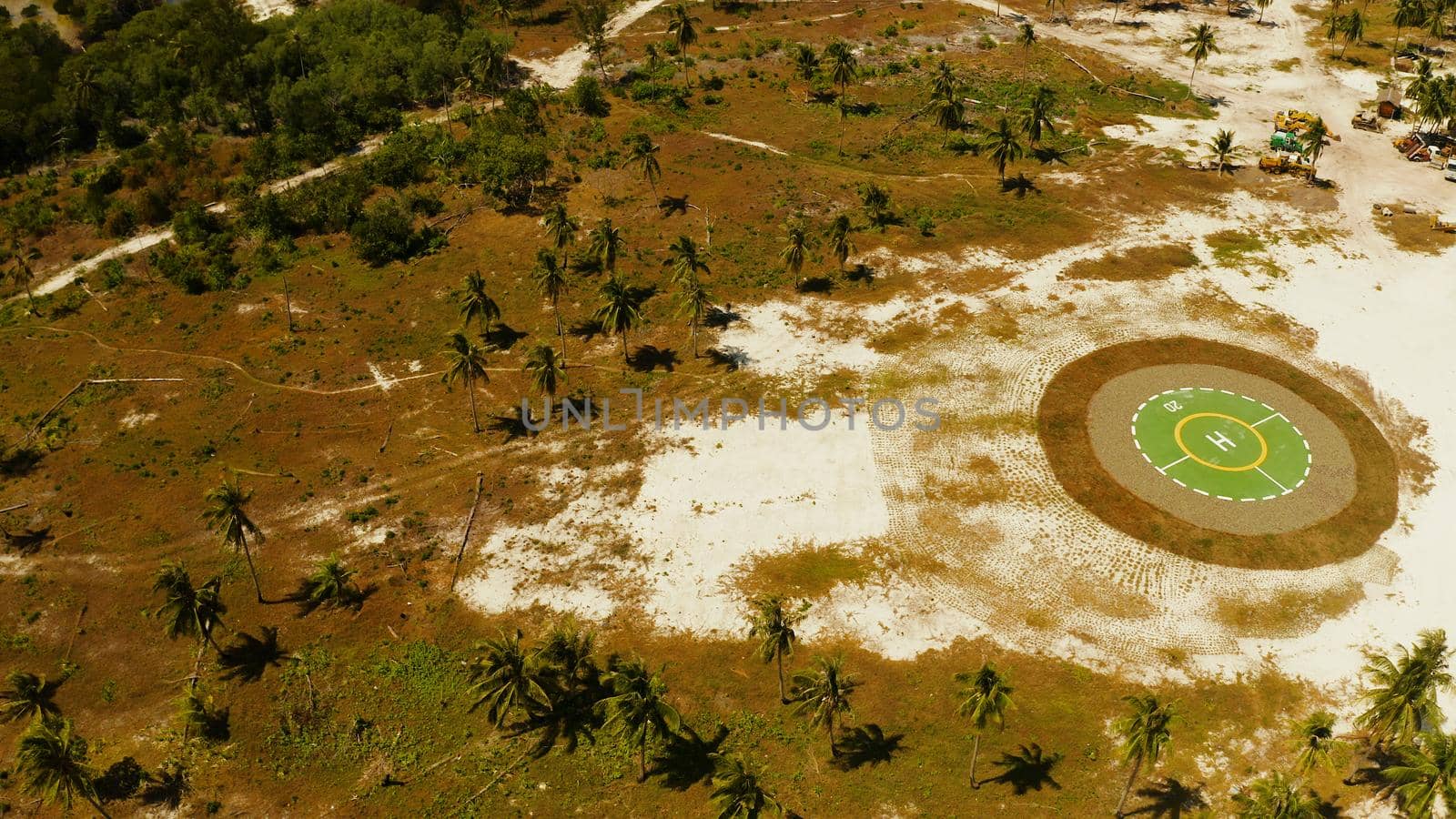 Helipad among the palm trees on a tropical island top view. Helicopter landing site. Bugsuk island, Balabac, Palawan