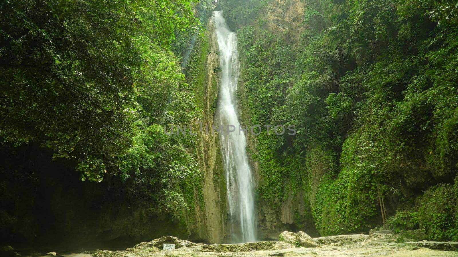 Waterfall in the rainforest jungle. Tropical Mantayupan Falls in mountain jungle. Philippines, Cebu.