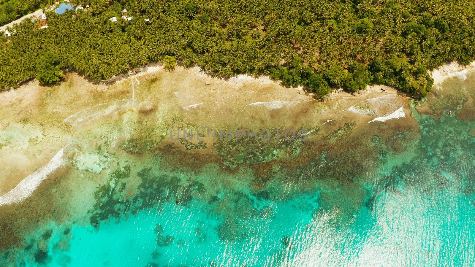 Ocean waves crashing on the shore and coral reef copy space for text. aerial view. Sea water surface in lagoon with coral reef. Summer and travel vacation concept.