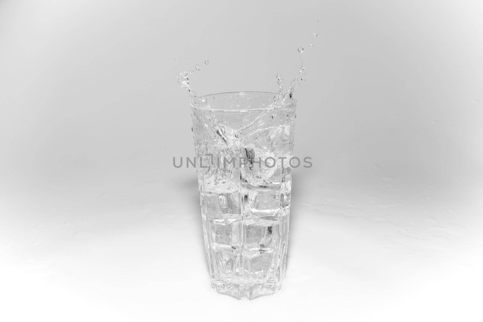 water splashes in a glass with ice on a white background. High quality photo