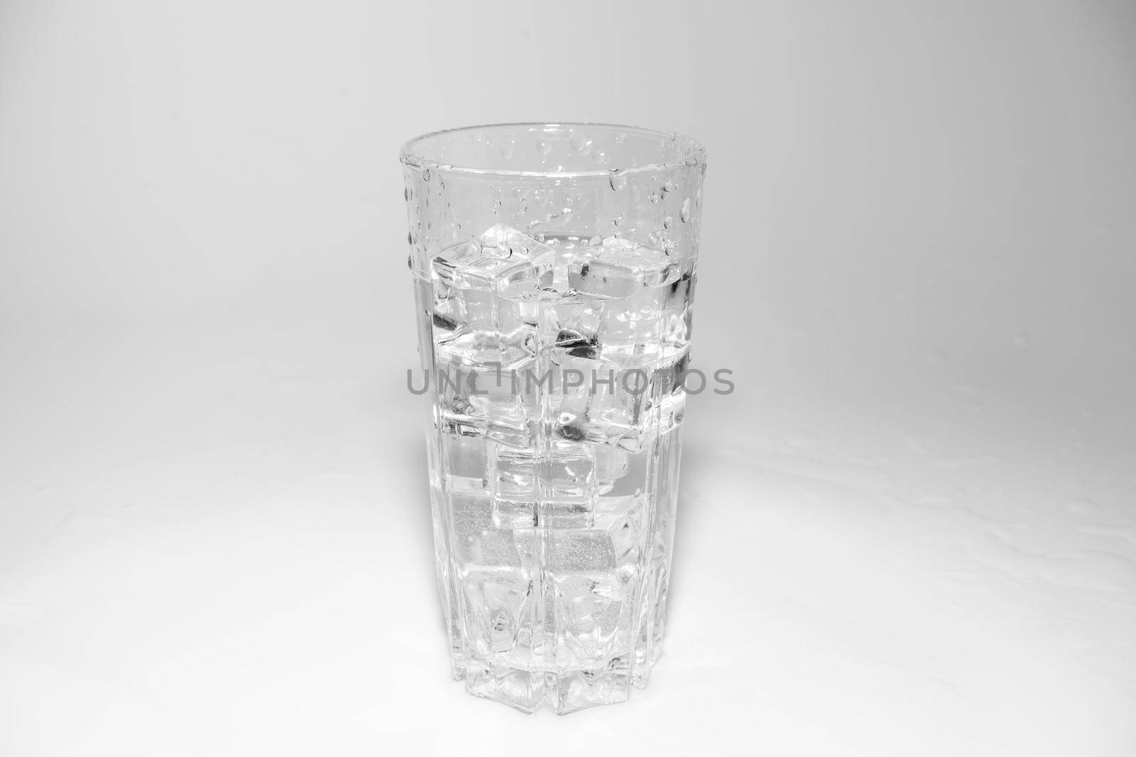 water splashes in a glass with ice on a white background. High quality photo