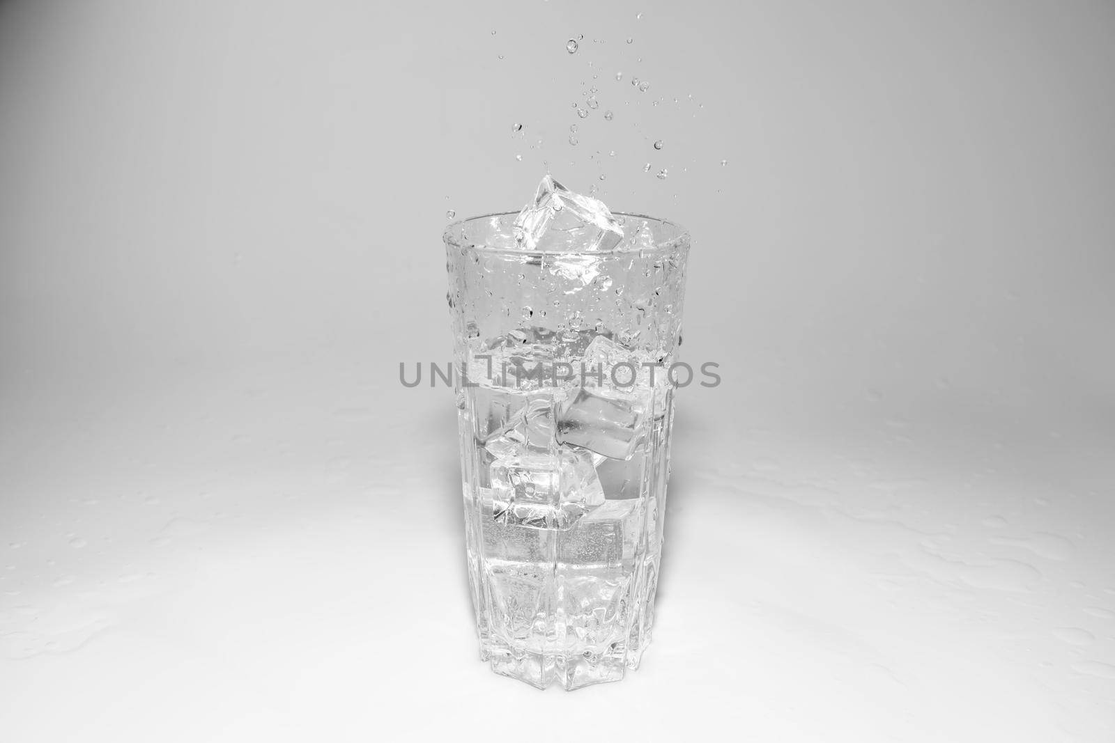 water splashes in a glass with ice on a white background. High quality photo