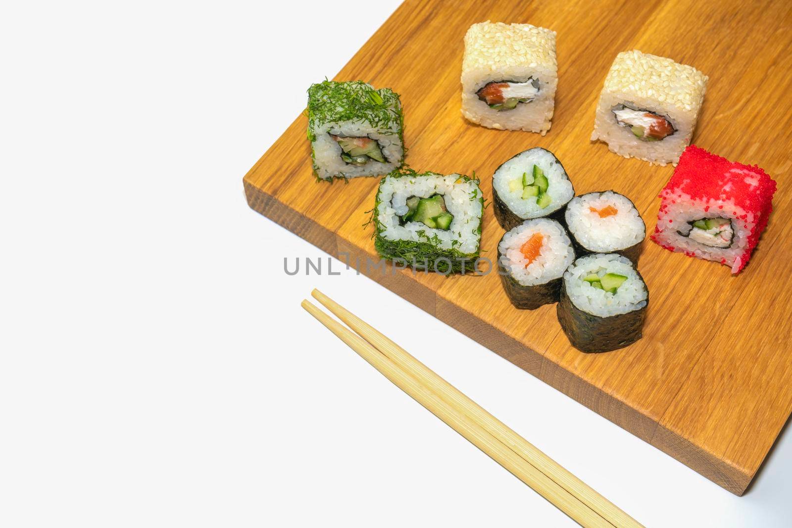 sushi and sticks on a wooden Board on a white background. High quality photo