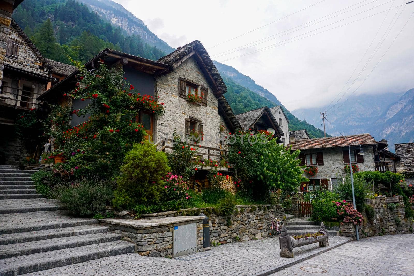 Traditional rustic stone house with lots of flowers in Sonogno, Switzerland by pisces2386