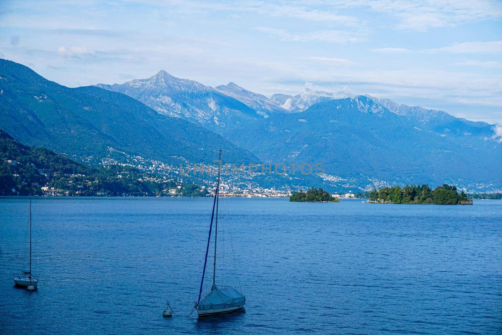Sail boats in front of impressing mountain range on the Lago Maggiore lake in the canton Ticino, Switzerland