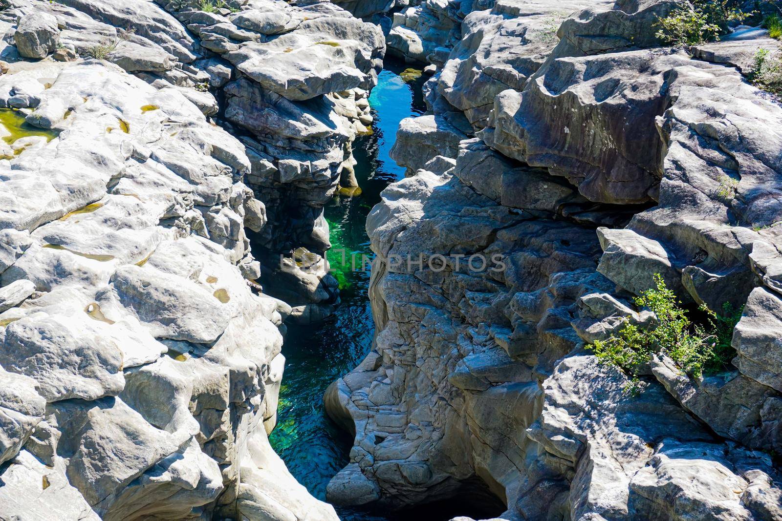 Close-up of a canyon formed by the Maggia river with lots of puddles and huge rocks