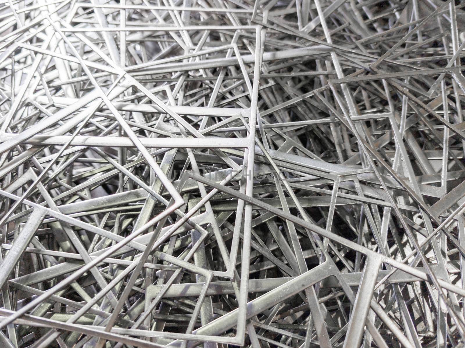 full frame abstract industrial background of stamping leftovers pile, close-up with selective focus.