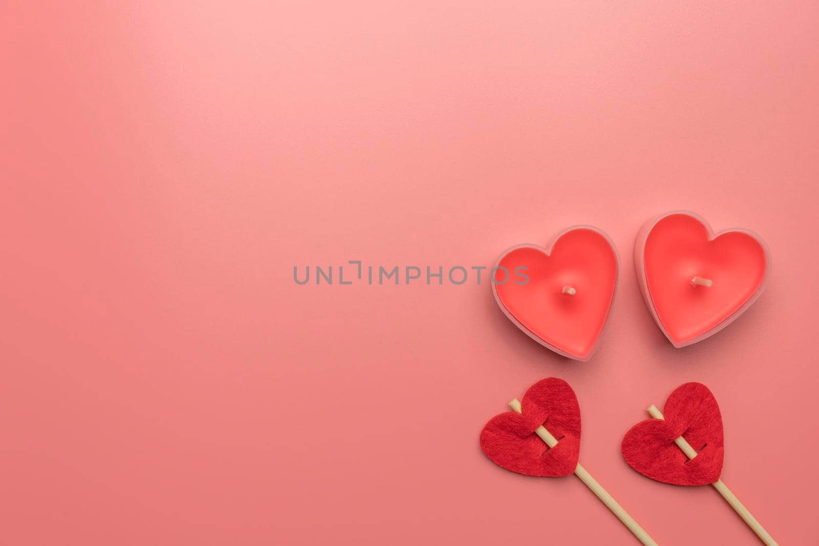 pink candles in the form of a heart on a red background for Valentine's day . High quality photo