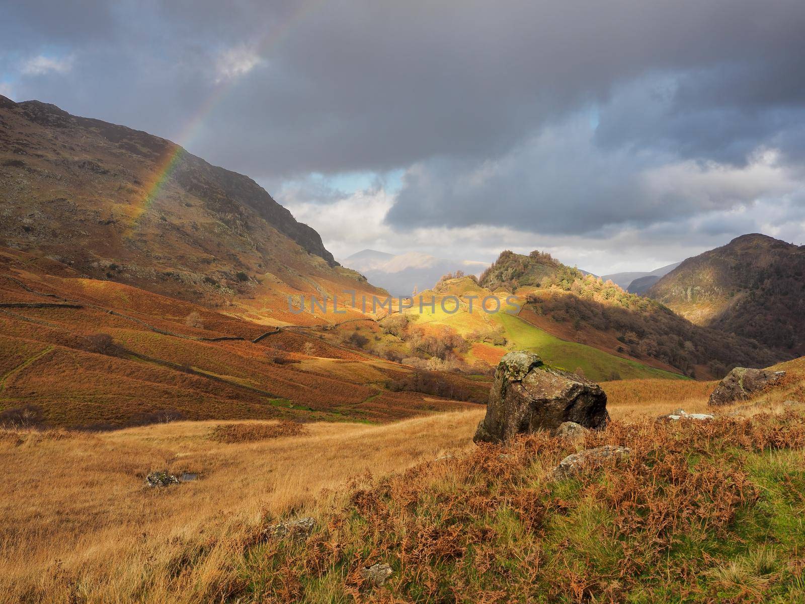 Rainbow arcing over Castle Crag and autumn colour near High Doat, Lake District by PhilHarland