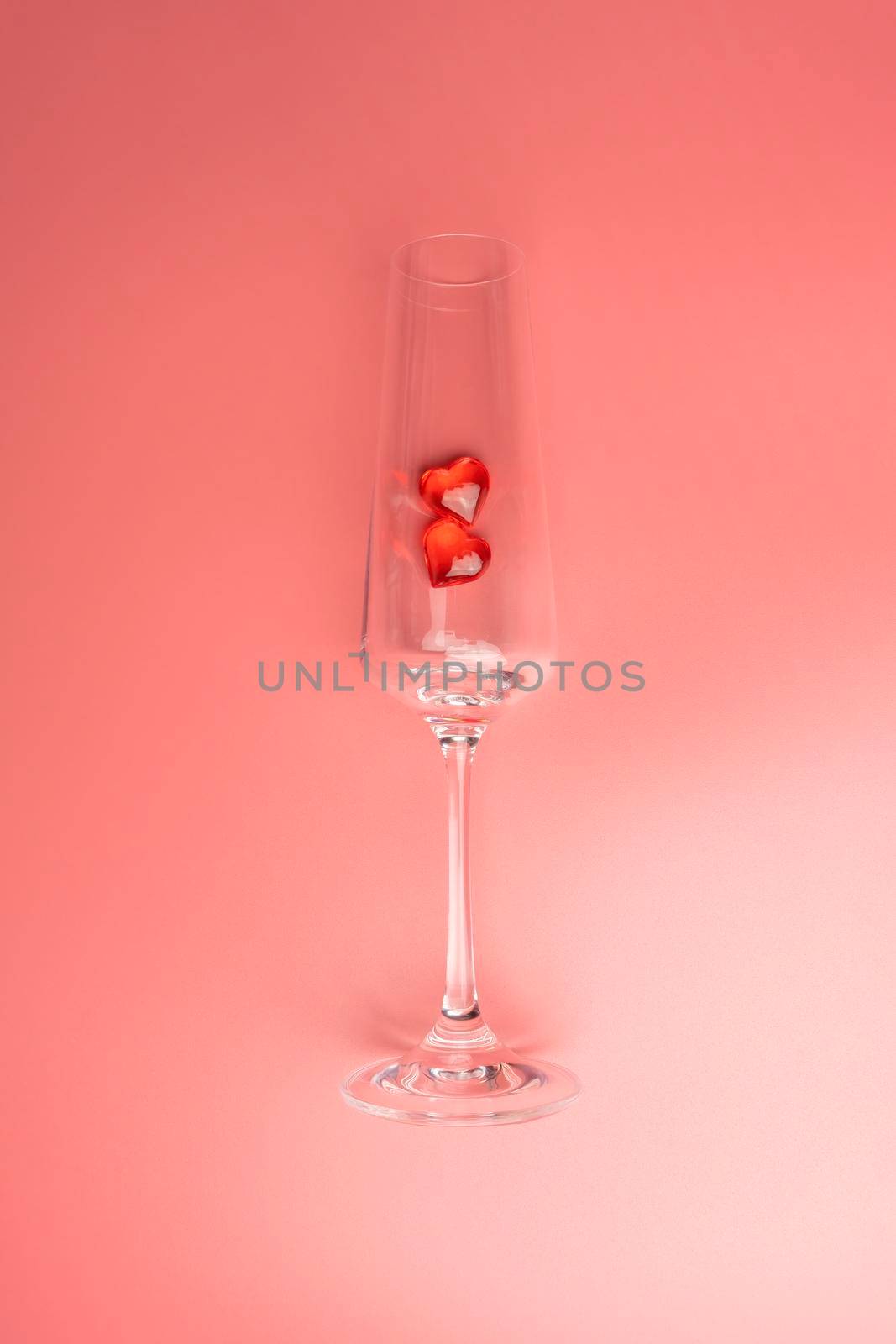wine glass with two hearts on a pink background. High quality photo
