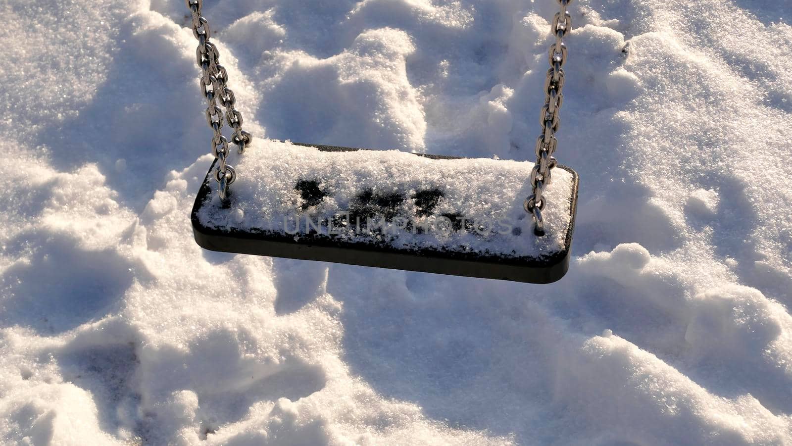 swing with snow cover in wintertime by Jochen