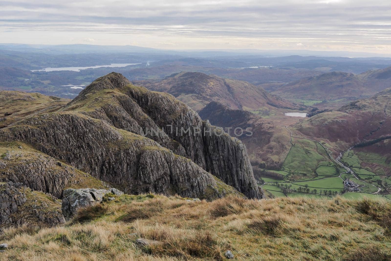 View to Loft Crag from Pike of Stickle overlooking the Great Langdale valley with Blea Tarn nestled in the fells and Windermere lake in the background, Langdale Pikes, Lake District, UK