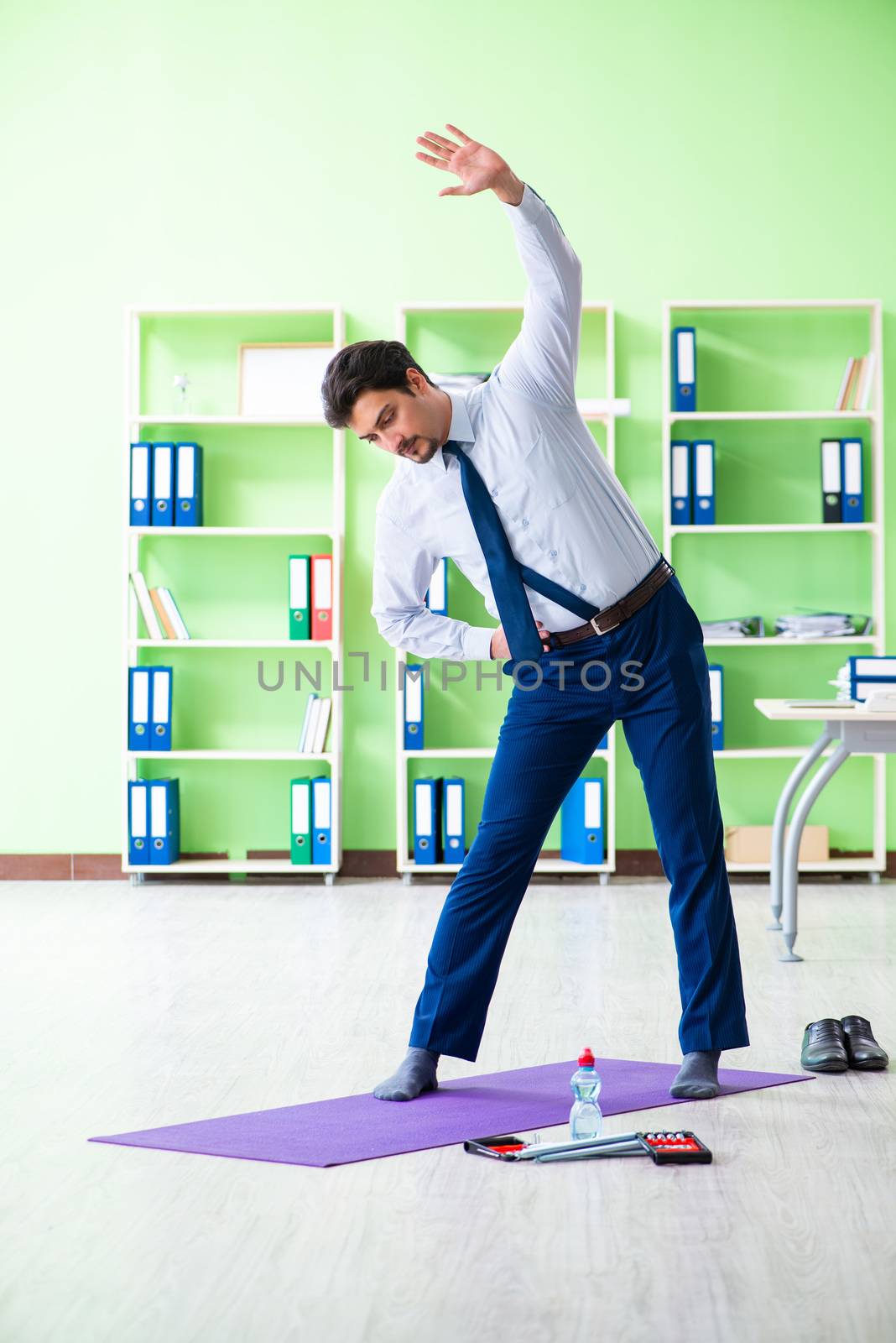 Employee doing exercises during break at work by Elnur