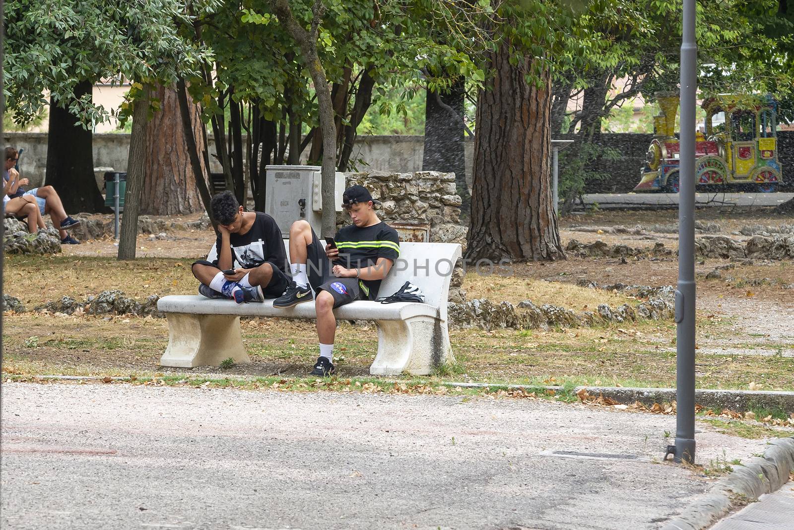 terni,italy august 16 2020:boys at the park with smartphones
