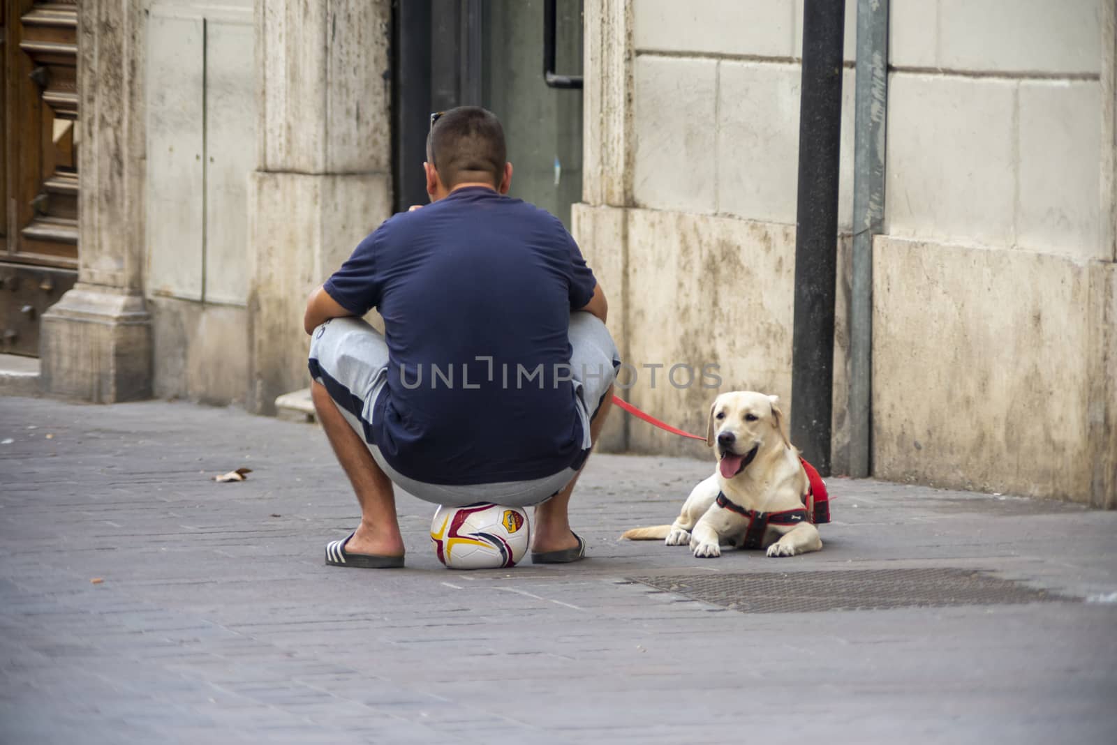terni,italy august 16 2020:man sitting on the balloon and near his labrador dog