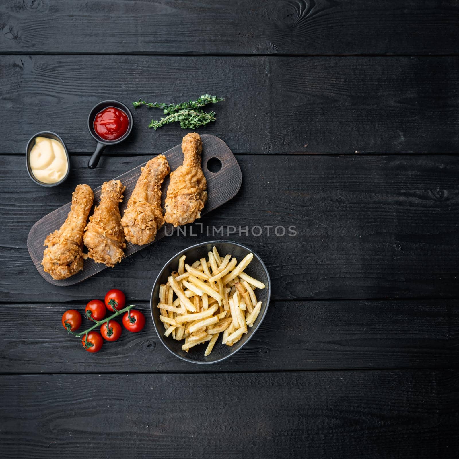 Crispy fried chicken leg on black wooden background, flat lay, with space for text by Ilianesolenyi