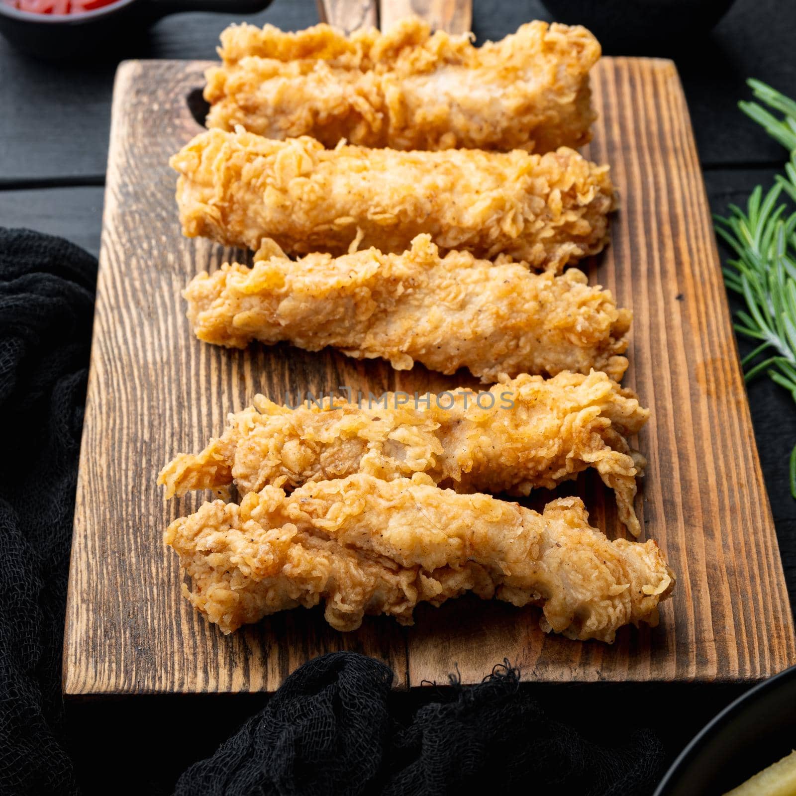 Chicken breaded wingshell meat on black wooden table.