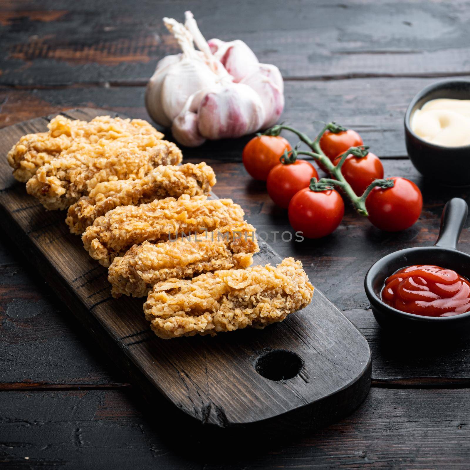 Spicy deep fried breaded chicken wings on dark wooden background by Ilianesolenyi