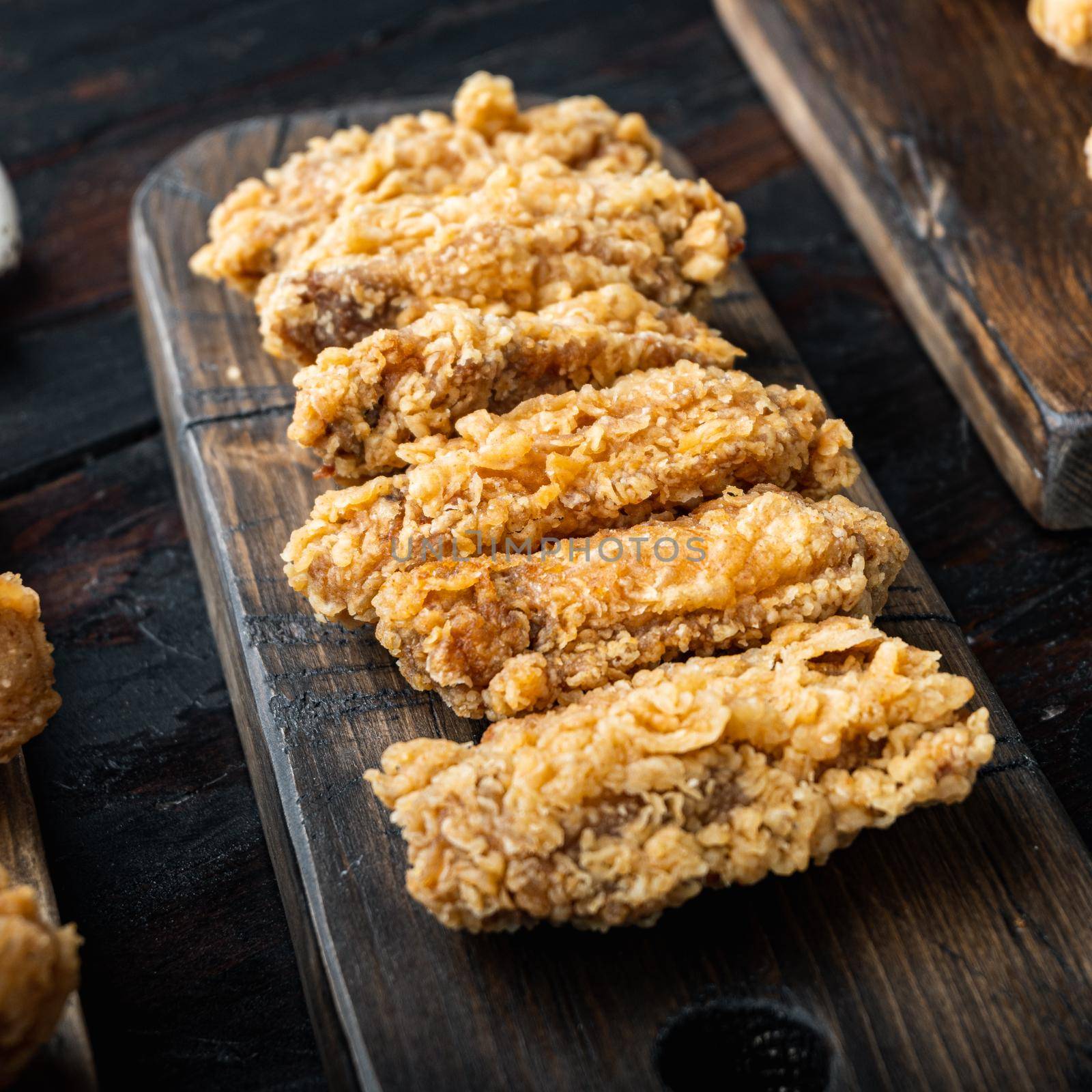 Spicy deep fried breaded chicken wings on dark wooden background by Ilianesolenyi