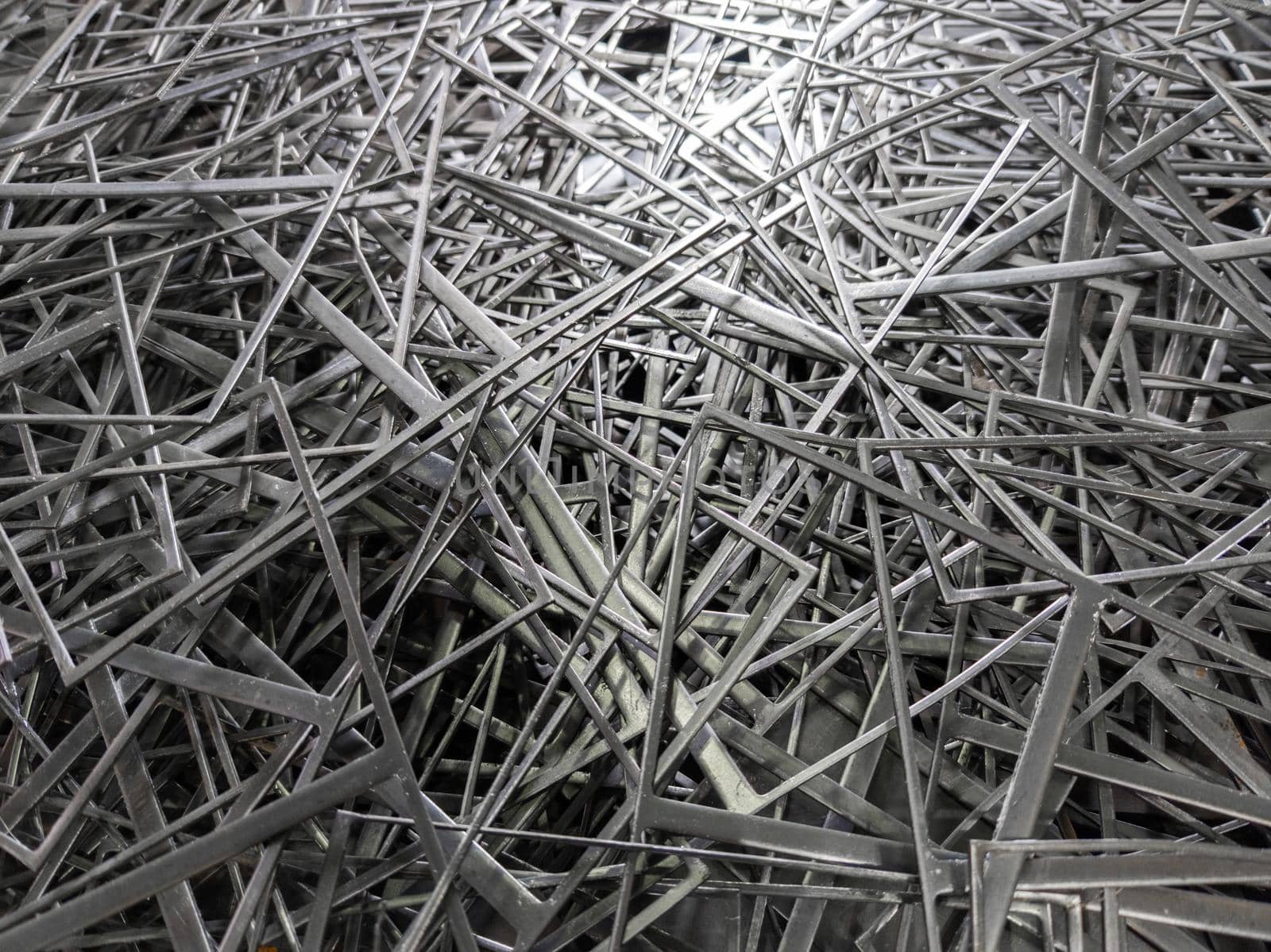 full frame abstract industrial background of stamping leftovers pile, close-up with selective focus.