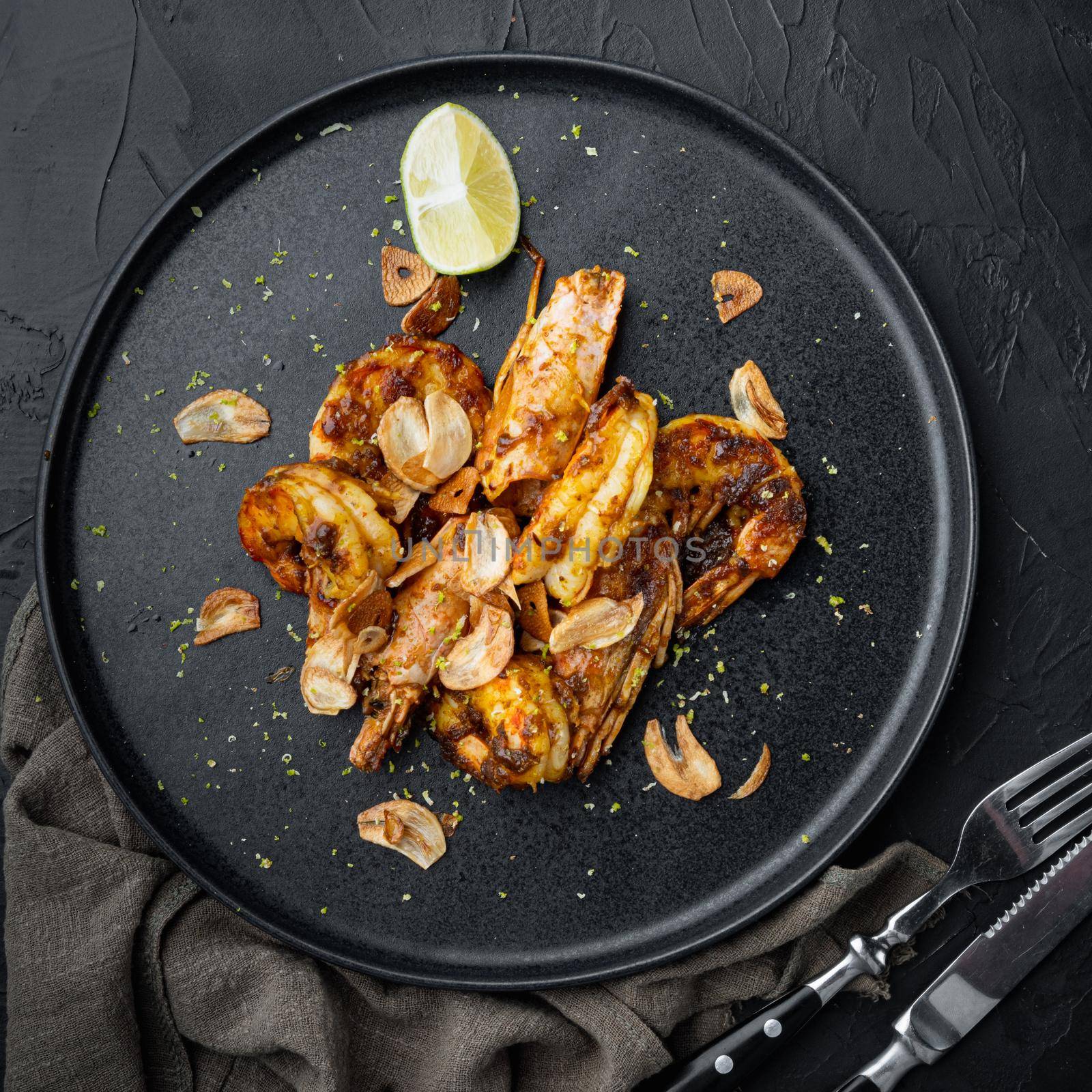 Large grilled BBQ shrimp with sweet Mango sauce and curry, on plate, on black background, top view flat lay by Ilianesolenyi