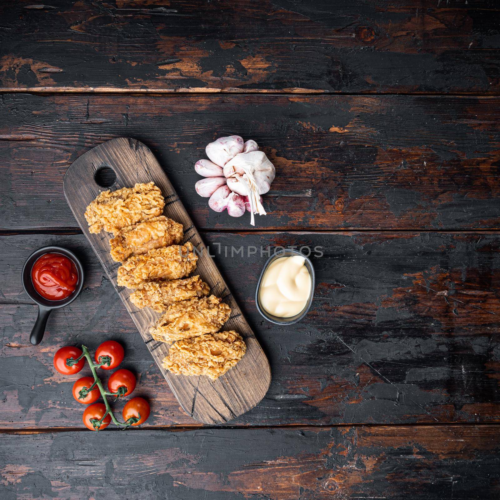 Spicy deep fried breaded chicken wings on dark wooden background, flat lay, with space for text by Ilianesolenyi