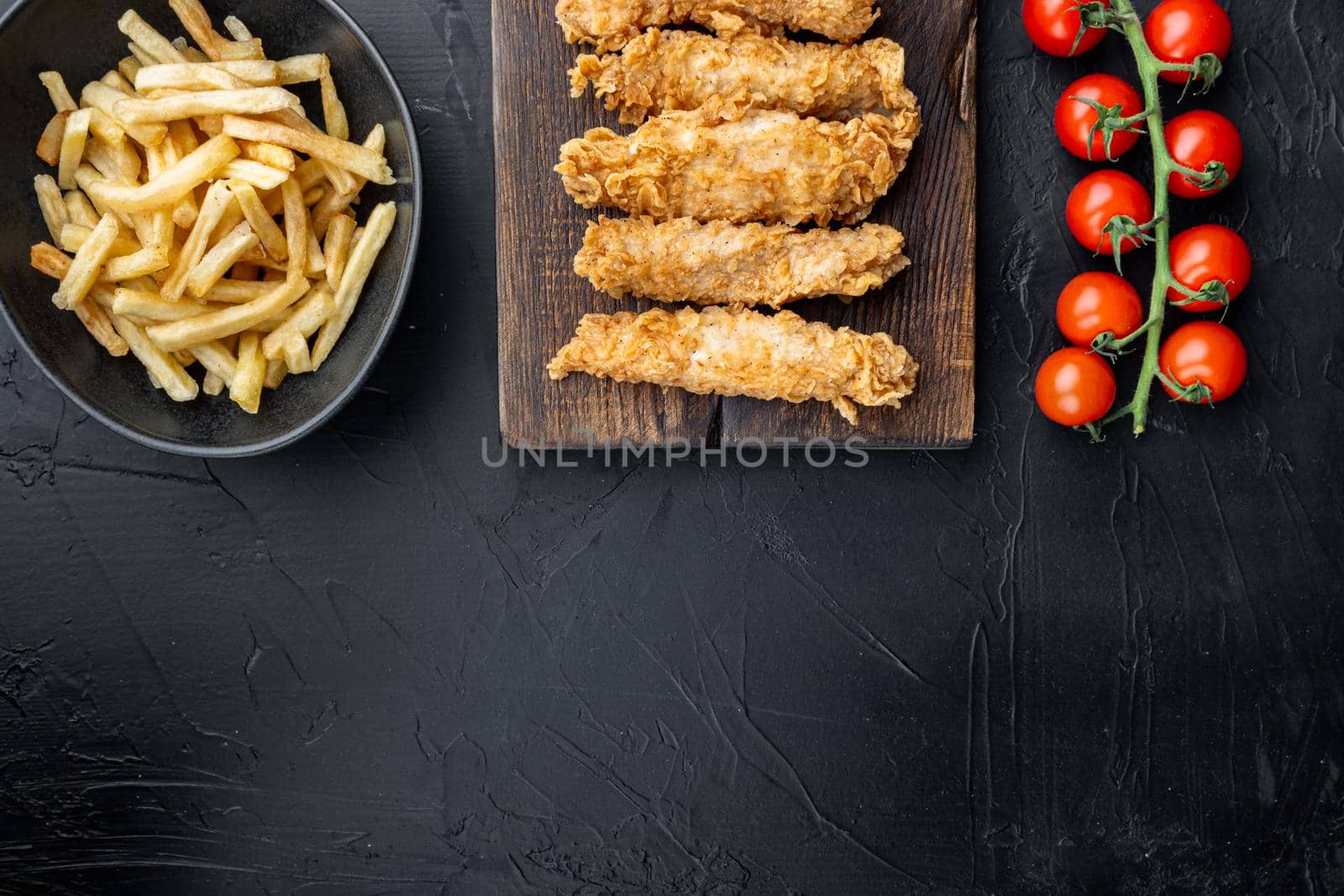 Crispy chicken tenders on black background, top view, with space for text by Ilianesolenyi