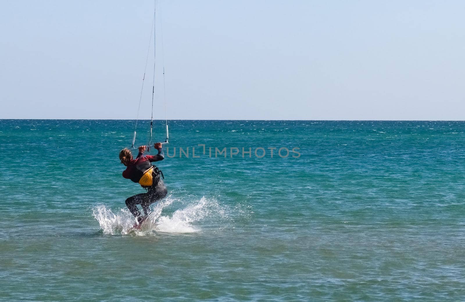 a kitesurfer surfing on the smooth azure water. recreational sport. A Man Rides A Kiteboarding In The Sea Water. extreme sport. High quality photo