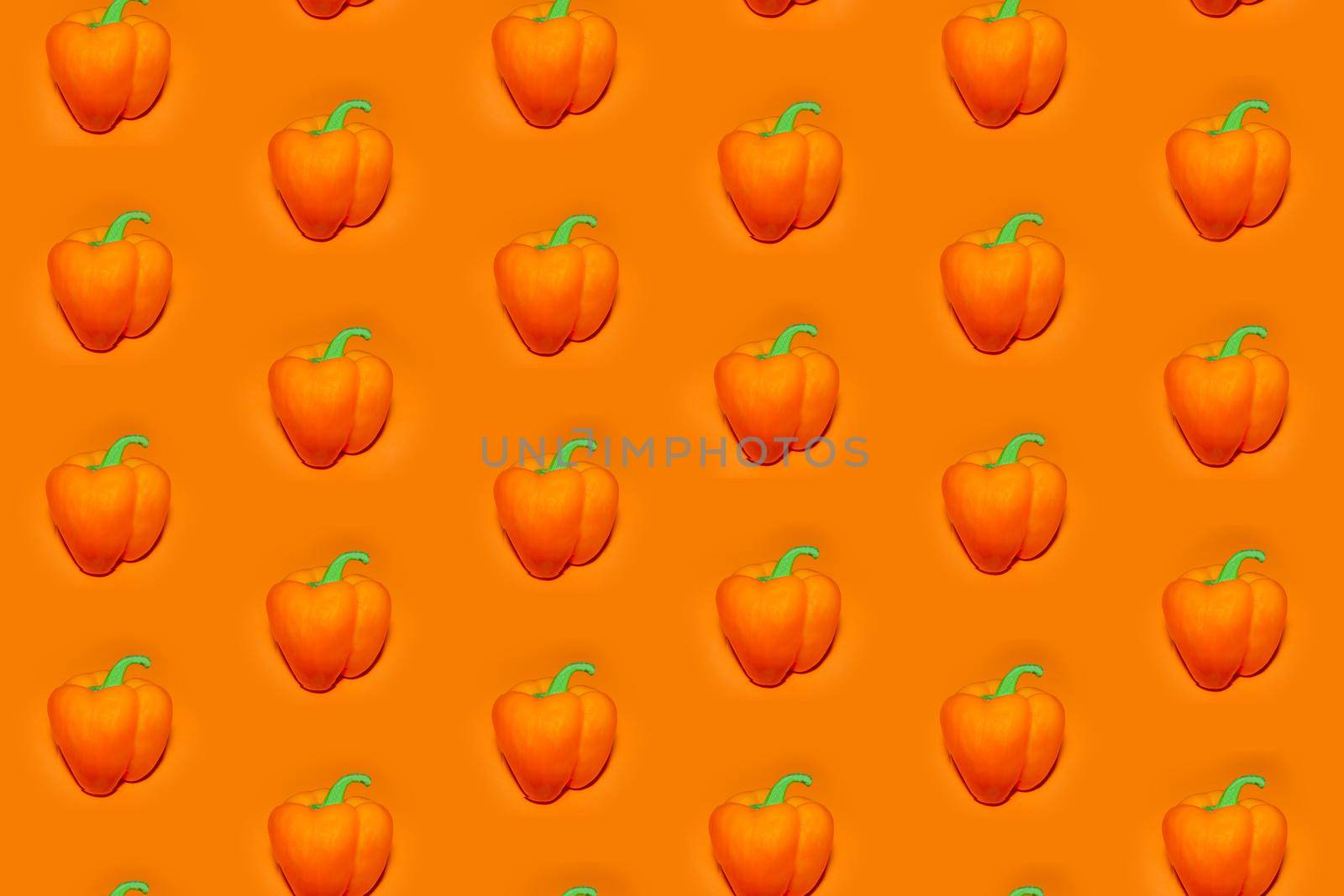 colorful vegetable pattern of orange bell pepper on an orange background. the pattern of bell pepper. the view from the top. High quality photo