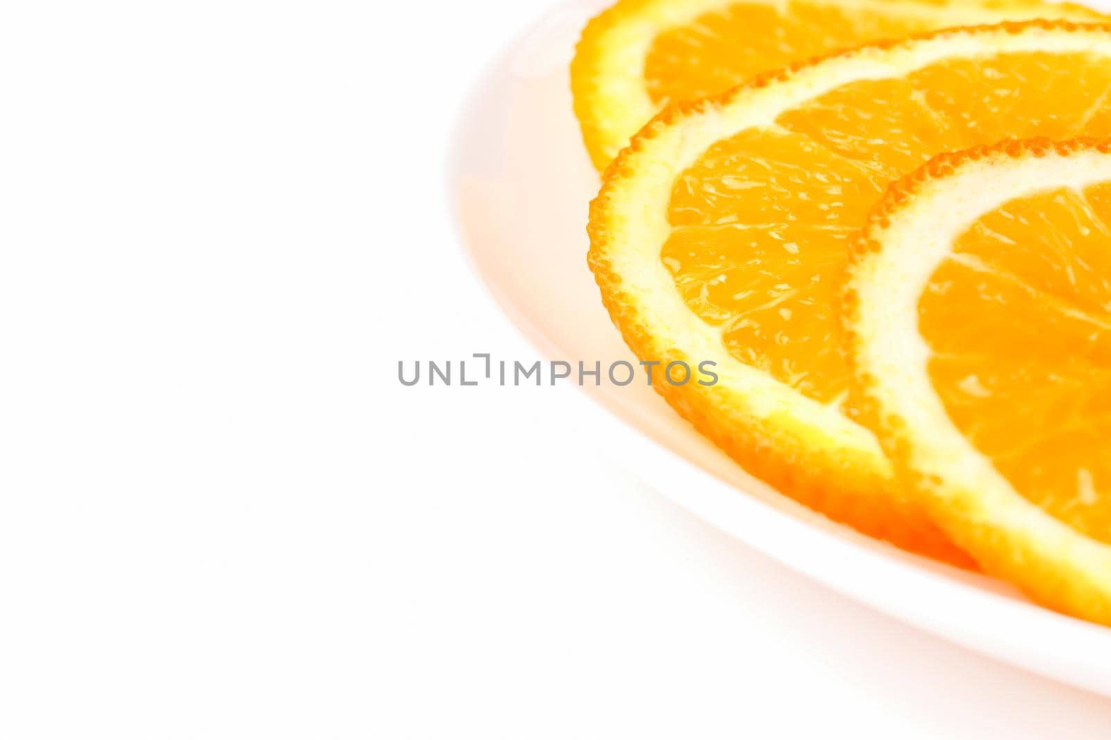 orange slices on a white plate on a white background. High quality photo