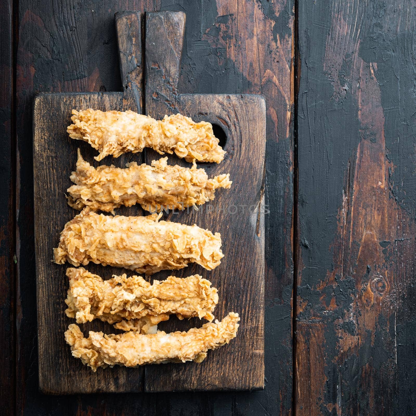 Chicken breaded breast on dark wooden background, top view, with space for text by Ilianesolenyi
