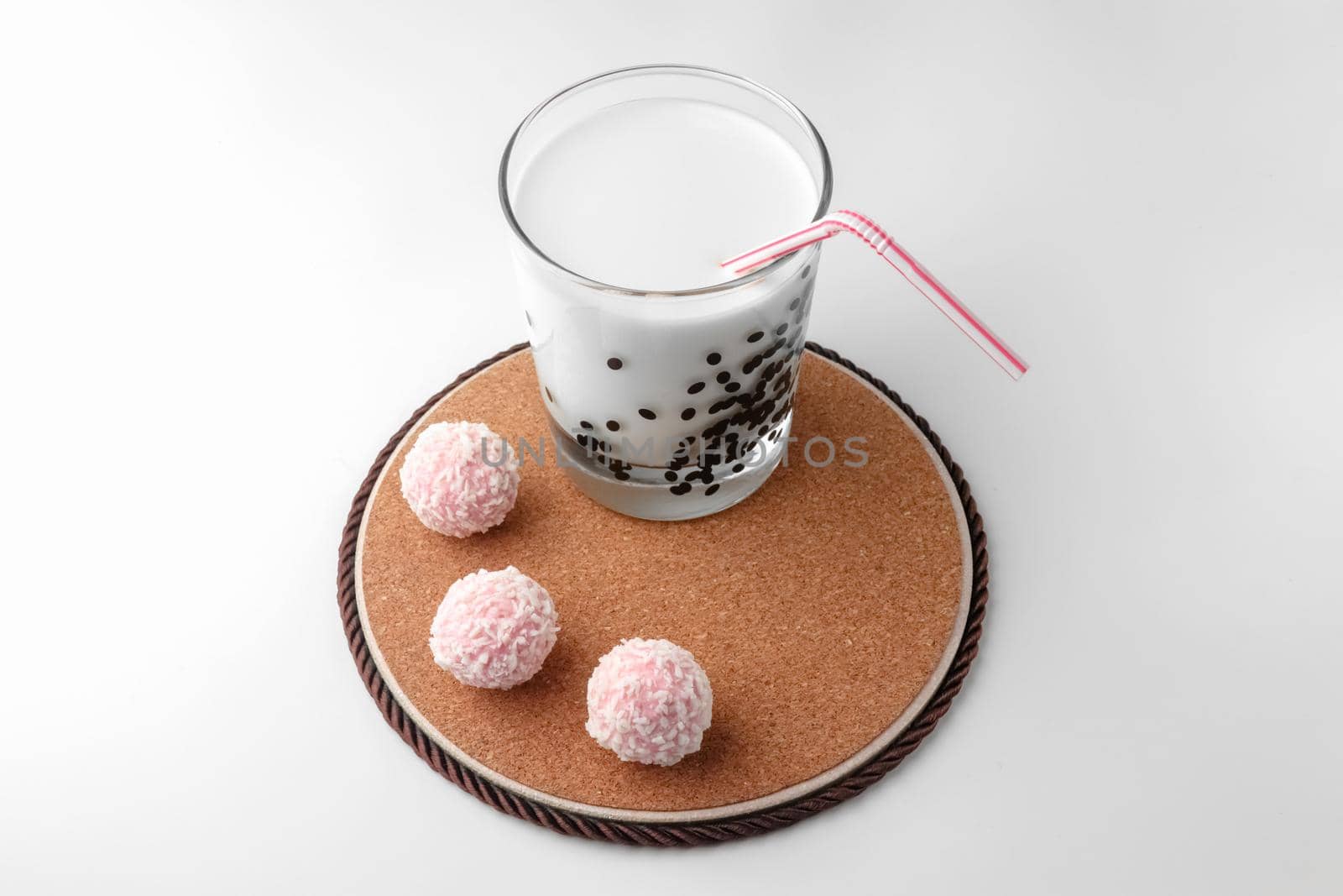 pink chocolate candy and a glass of milk on a white background. candy ball macro. isolate. High quality photo