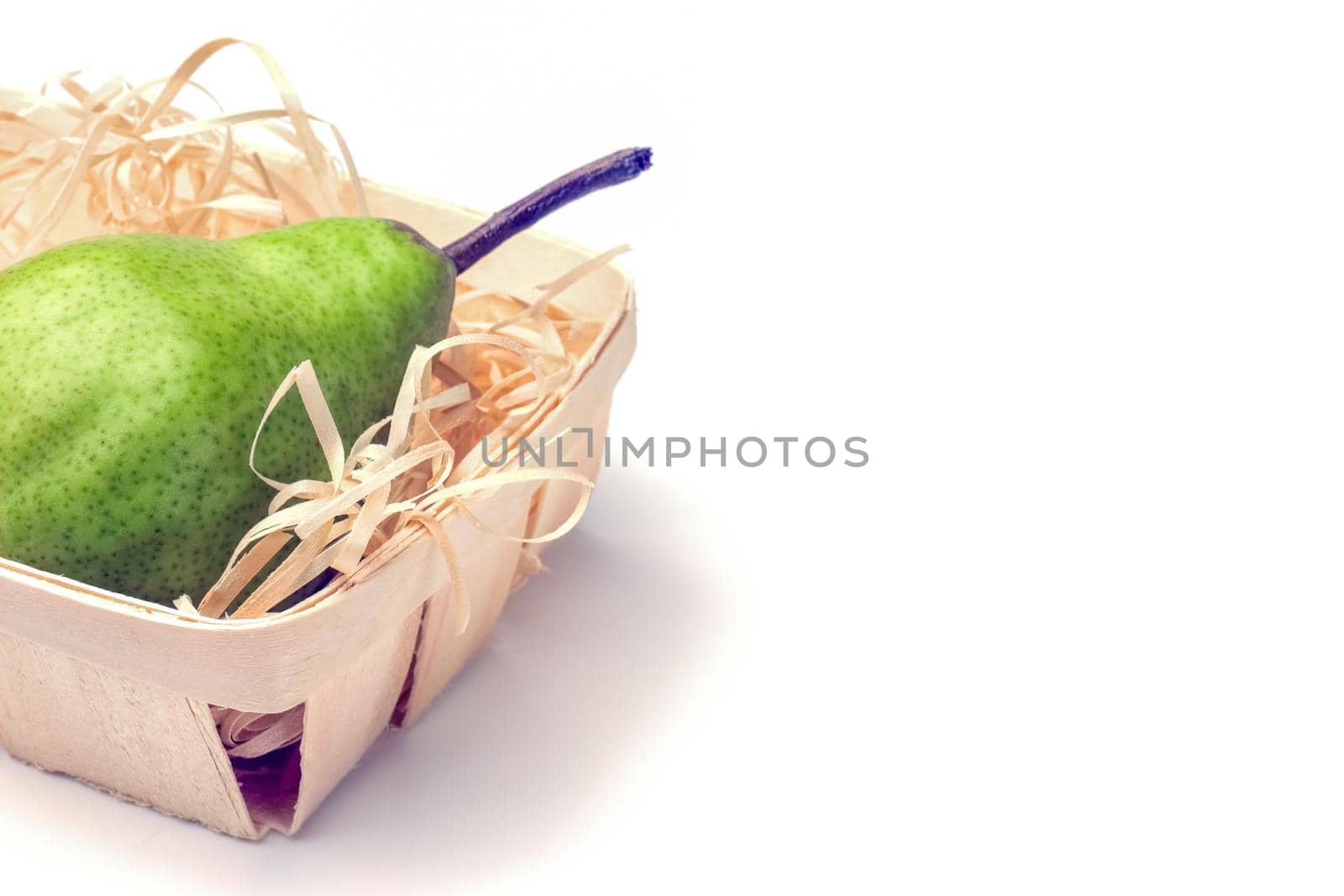 green pear in a basket close-up on a white background. High quality photo