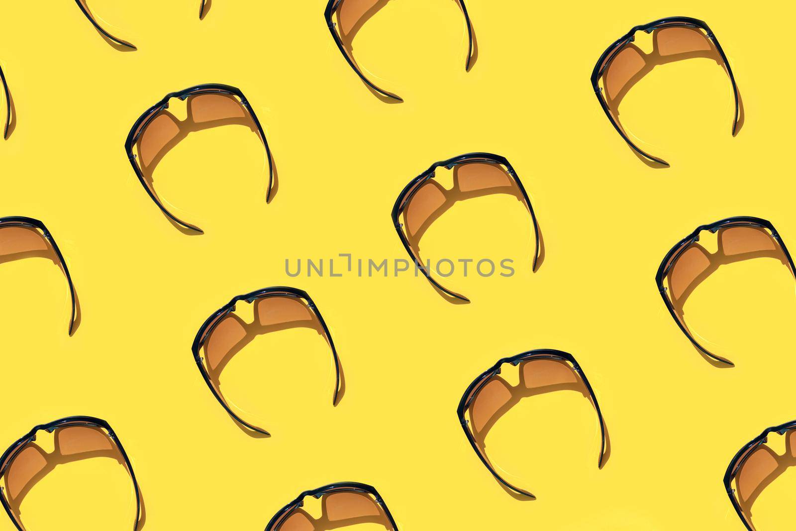colorful pattern of sunglasses on a yellow background top view. High quality photo