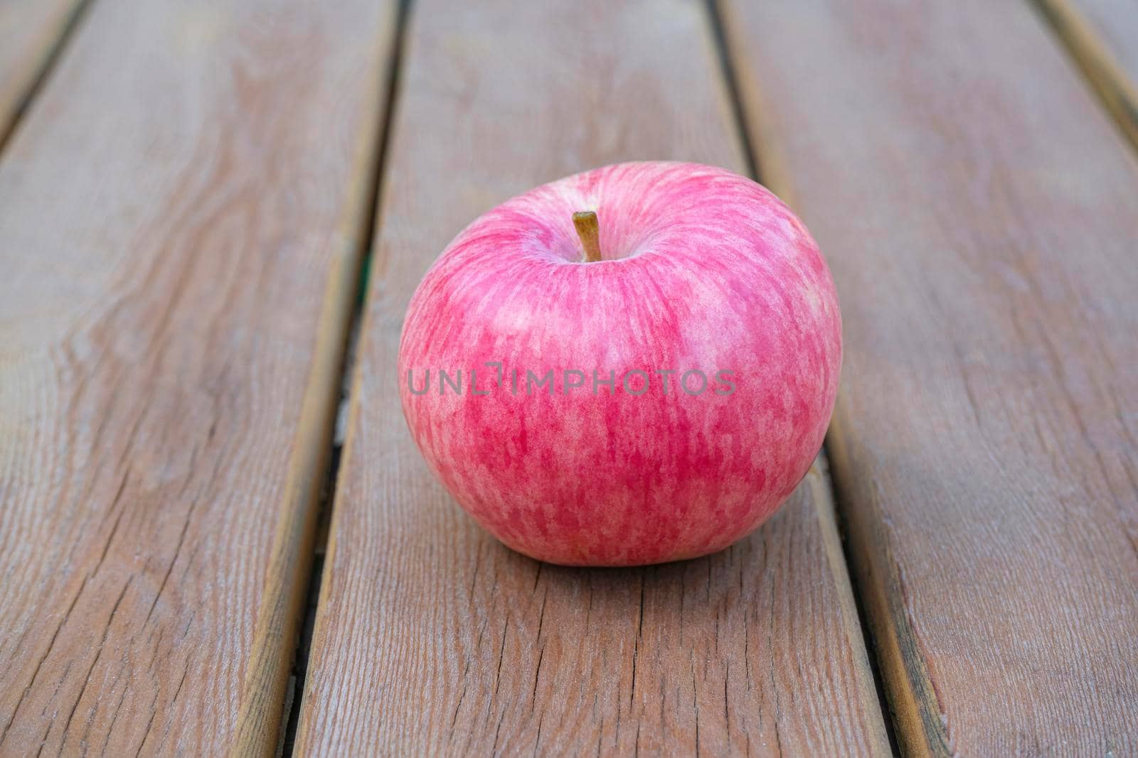 red Apple on a wooden table close-up by roman112007