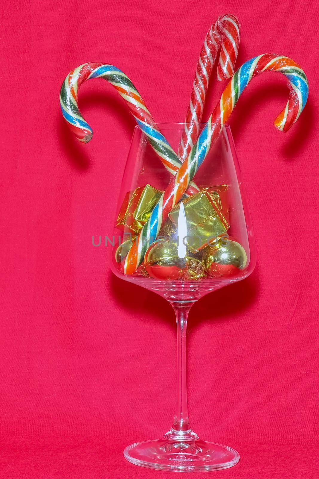 wine glass with Christmas decorations on a red background. high-quality photos