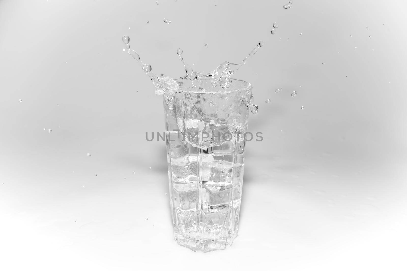 water splashes in a glass with ice on a white background. High quality photo