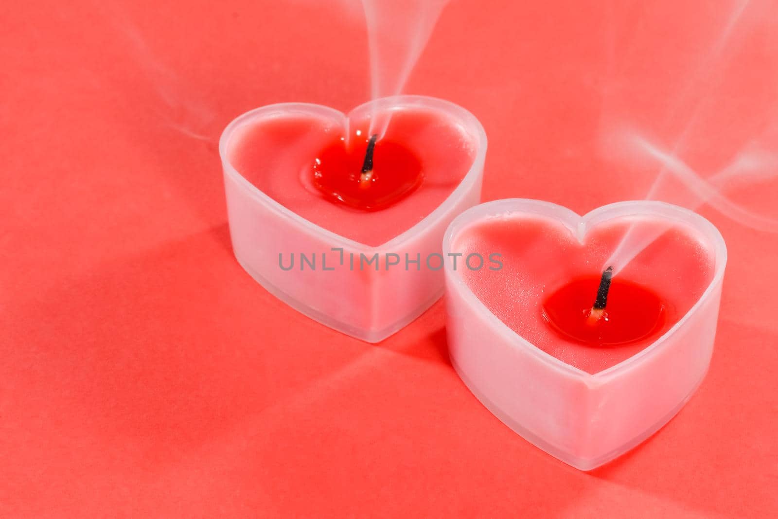 pink candles in the form of a heart on a red background for Valentine's day . High quality photo