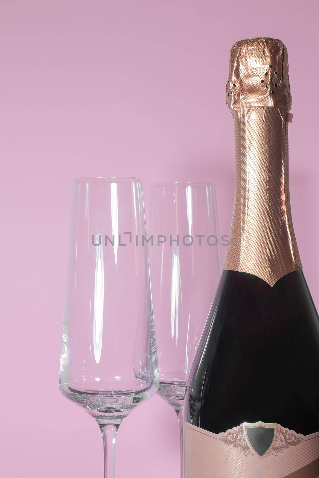 bottle of champagne with glasses on a pink background by roman112007